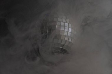 Yoğun dumanların arasında bir disko topunu yansıtan ikonik görüntü, aynalardan yansıyan ışık nostaljiyi geçmişe dönük partiler ya da kulüp gecelerine çağrıştırıyor