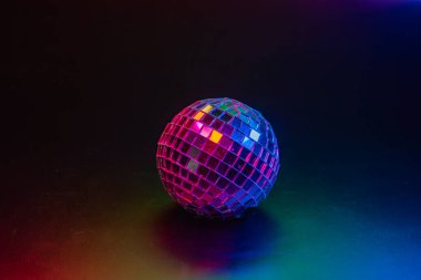 Eski bir parti ortamında renkli ışıklar saçan bir disko topu.