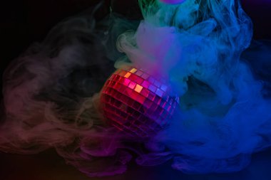 Sisin içinde gökkuşağı ışıklarıyla parlayan bir disko topunun canlı görüntüsü parti atmosferini çağrıştırıyor.