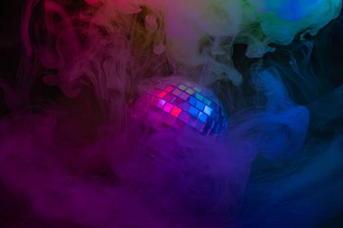 Görüntü, gece hayatını ya da parti sahnelerini temsil eden enerjik bir parıltıyla renkli ve belirsiz efektlere karşı bir disko topu sergiliyor