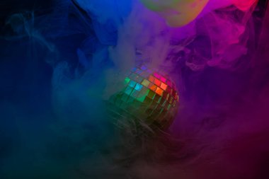 Canlı bir stok görüntüsü, renkli dumanlarla çevrili bir disko topunu, pazarlama ve reklam amaçlı parti ve gece hayatı ortamını, eğlence, sosyal toplantılar ve