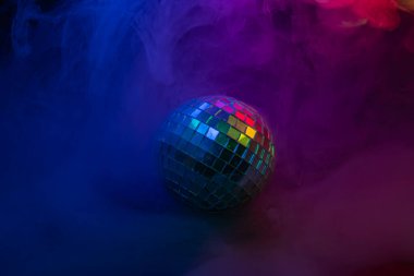 Canlı bir disko sahnesi, canlı bir disko topu, mor ve mavi arkaplan, eğlence için pazarlamada, partilerde, müzik etkinliklerinde veya eğlence temalarında kullanılan gece kulüplerini veya partileri anımsatıyor.