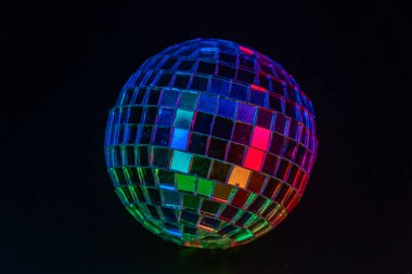 Dönen bir disko topu canlı renkler sergiliyor, parti olaylarını sembolize ediyor veya nostaljik retro deneyimleri