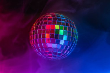 Dönen bir disko topunun canlı bir görüntüsü. Gece hayatı ve eğlence ile ilişkili enerji ve heyecanı yakalıyor.