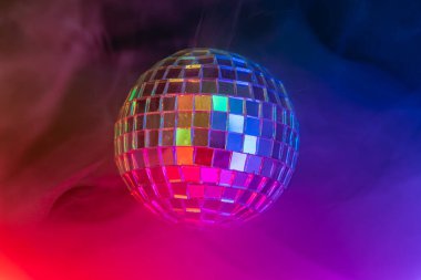 Canlı, renkli bir ışıkta disko topu, renkleri yansıtan, dans kulüpleri partilerini hatırlatan, neşeli bir atmosfer yaratan...