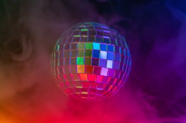 Bir disko topunun canlı bir gradyanı mordan turuncuya yansıtması, neşeli ya da kutlama atmosferindeki ışıkları yansıtması, genellikle eğlenceyi ve canlı toplantıları sembolize eder.