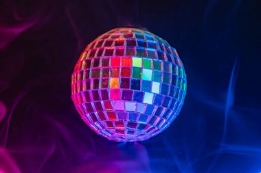 Disko topu, parti sahneleri, partiler, konserler, gece kulüpleri ya da müzik ve eğlence gibi etkinliklerle ilişkilendirilen hareketli ışıklarla dolu, karanlık, dumanla dolu bir arka planda yüzüyor.