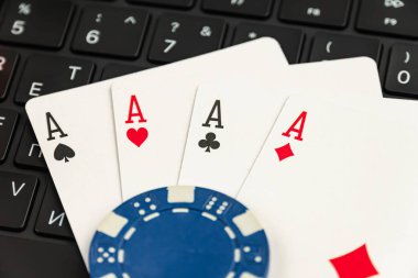 Bir bilgisayar klavyesi önünde Ace of Mades 'in öne çıktığı bir iskambil kağıdı koleksiyonu, kumarhaneler ve kart oyunlarıyla ilgili çevrimiçi kumar veya dijital eğlence temaları içeriyor