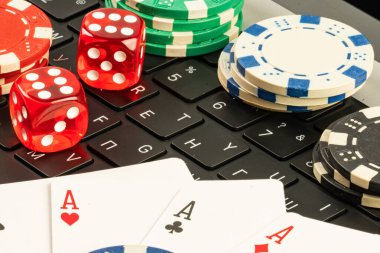 Oyun kartları, kumarhane çipleri ve bilgisayar klavyesi gibi oyun unsurlarını tasvir eden resim, Las Vegas 'taki kumar deneyimlerinde şans, risk ve heyecanı simgeliyor.