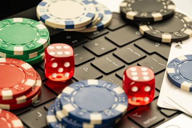 Görüntü, poker fişlerini ve zarları siyah bir zemine karşı gösteriyor. Bu da bir oyun ya da kumar temasını işaret ediyor.