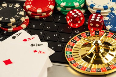 Kumarhane eşyalarının düzenlenmiş bir koleksiyonu, kumar kağıtları, kumar fişleri, kumar fişleri, rulet çarkları, muhtemelen online oyun arkaplanı ile ilişkili heyecan ve cazibeyi akla getiriyor.