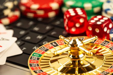 Görüntü, rulet çarkı, poker fişi ve kart gibi kumar eşyalarının olduğu bir kumarhane sahnesi gösteriyor. Atmosfer hem çevrimdışı hem de online oyun olduğunu gösteriyor.