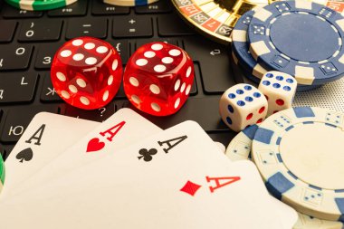 Kumarhane eşyaları, zar, iskambil kağıtları, maça ası, çip ve bir klavye üzerinde düzenlenmiş renkli stok imajı kumar, oyun, eğlence, risk alma, finans konuları
