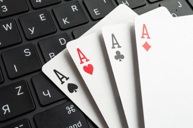 Bulanık ofis geçmişine karşı beş oyun kartından oluşan yakın plan, oyun ve çalışma ortamını sembolize ediyor.