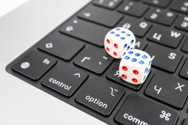 Bir klavyede teknolojiyle ilgili bir şansı veya rastgeleliği sembolize eden iki zarın yakın plan görüntüsü