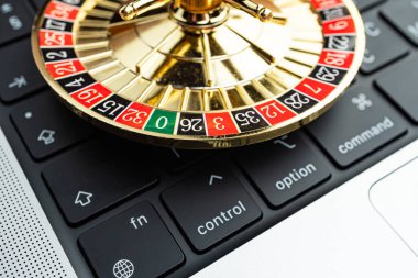 Çevrimiçi oyun, finans veya teknoloji alanında şans, risk ve karar vermeyi sembolize eden, bir bilgisayar klavyesindeki dönen rulet tekerleğinin yakın plan görüntüsü