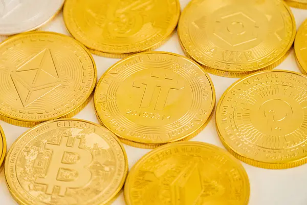 B logolu altın Bitcoin paraların havadan görünüşü, şifreli para birimini sembolize ediyor, satırlar halinde dizilmiş, zenginliği ve potansiyel büyümeyi temsil ediyor.