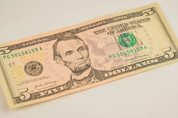 Abraham Lincoln Sharp odaklı, doğal ışık, değeri veya finansal temayı sembolize eden beş dolarlık banknotun yakın plan fotoğrafı