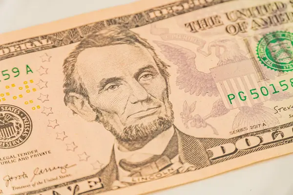 Abraham Lincoln 'un portresi ile net bir Amerikan dolarının yakın plan görüntüsü odak noktası keskin, seri numaraları ve baskı izleri gibi ayrıntıları vurguluyor.