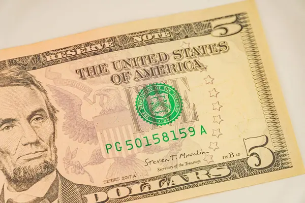Abraham Lincoln 'ün portresini, seri numaralarını ve Federal Rezerv Bölgesi mührünü vurgulayan iki ABD 5 banknotunun yakın plan görüntüsü, yüzgeç için ABD para biriminde güvenlik tedbirleri ve tasarım unsurlarını tartıştı