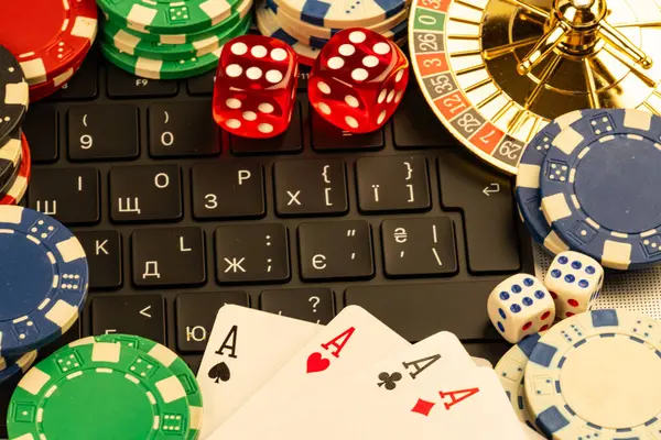 Kartlar, zarlar ve rulet tekerleği olan bir kumarhane ayarları bulanık bir ofis veya çalışma alanı zeminine karşı resmedilmiş.