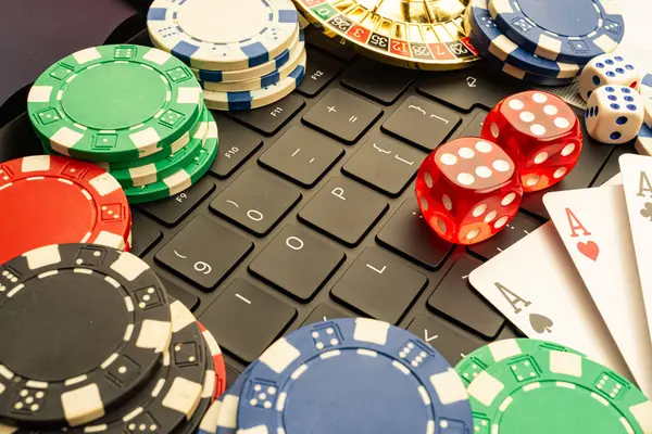 Görüntü canlı kumarhane fişleri sergiliyor ve desenli bir oyun yüzeyi üzerinde kağıt oynuyor, özellikle poker ya da blackjack gibi kumar kültürüne işaret ediyor.