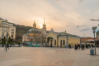 Tarihsel mimarisi olan hareketli bir Avrupa şehir meydanı, arka planda eski bir kilise, dükkan ve lokantalardan canlı bir atmosfer, öğleden sonra Kyiv, Ukrayna, 09-15-2024