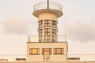 Okyanus platformunda modern, silindirik bir deniz feneri. Üst düzey bir gözlem güvertesi ve sıcak gün batımı parlaması Kyiv, Ukrayna, 09-15-2024