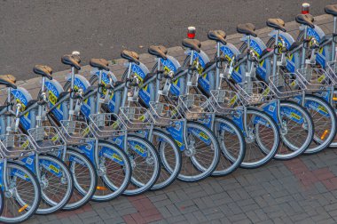 Kentsel hareketliliği ve çevre dostu ulaşımı sembolize eden bir bisiklet paylaşım programına yerleştirilmiş mavi bisikletler Kyiv, Ukrayna, 09-15-2024