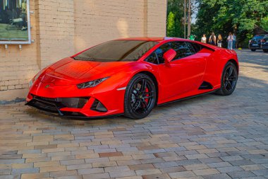 Canlı kırmızı bir Lamborghini spor arabası bir tuğla sokağa park edilmiş, lüks ve kentsel çekiciliğini sergiliyor Kyiv, Ukrayna, 09-15-2024