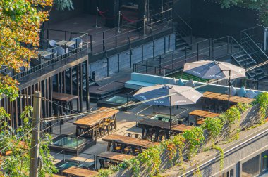 Bir kafe restoranının açık hava oturma alanı. Al fresco yemek ve rahatlama için mükemmel. Mutfak sunumları ve estetiklerde kullanılıyor.