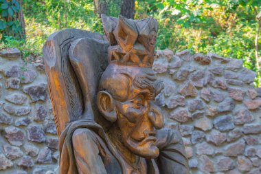 Görüntü, açık hava parkında ya da bahçe düzeninde oturan büyük, muhtemelen kraliyet figürünün heykelini gösteriyor. Heykel ayrıntılı ve heybetli, Ukrayna, 09-15-2024