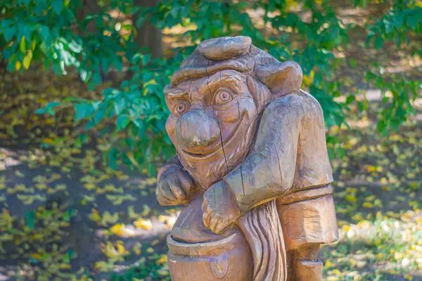 Abartılı özellikleri ve arkadaşça ama zararlı görünümlü ahşap bir cüce, sonbaharda açık havada resmedilmiştir. Kyiv, Ukrayna 'da zanaat, 09-15-2024