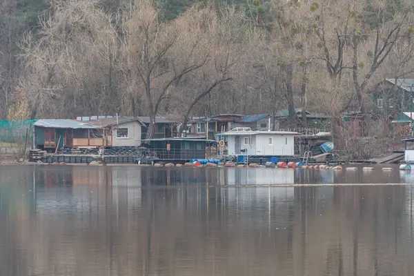 Rıhtımlı ve demirli tekneli çok sayıda evin yer aldığı bir deniz kenarı toplumunun havadan çekilmiş görüntüleri. Yine de sular yapıları ve Kyiv, Ukrayna, 09-15-2024 yıllarını yansıtıyor.