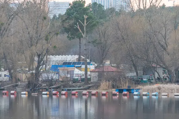 Renkli teknelerle sakin rıhtım manzarası, sakin su yansıtan ağaçlar ve binalar, yemyeşil alan, gevşeme ve doğayla bağlantı, seyahat için uygun, Kyiv, Ukrayna, 09-15-2024