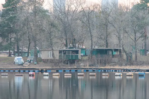 Ahşap rıhtım, mavi şamandıralar, kayıkhaneler, yeşillikler, ağaçlar ve balıkçılık ya da eko-turizm Kyiv, Ukrayna, 09-15-2024 gibi su faaliyetleriyle sakin bir göl manzarası