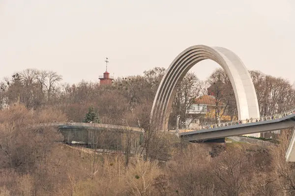 Su üzerinde yeşil ve nehir kıyısı olan modern, eğimli bir köprünün havadan çekilmiş görüntüleri mühendislik, altyapı, kentsel planlama ve mimari tasarım meraklıları Kyiv, Ukrayna, 09-15-2024