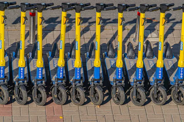 Modern bir ortamda sarı ve mavi renkli elektrikli scooterların temiz ve organize bir gösterisi, yenilik, rahatlık ve çevre dostu Kyiv, Ukrayna, 09-15-2024