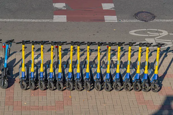 Bir tuğla yüzey üzerinde sarı ve mavi renkli tekdüze bir sıra bisiklet, şehir sakinleri için kamu veya ortak bisiklet sisteminin bir parçası, kolaylık ve çevre dostu taşımacılık sistemi Kyiv, Ukrayna, 09-15-2024