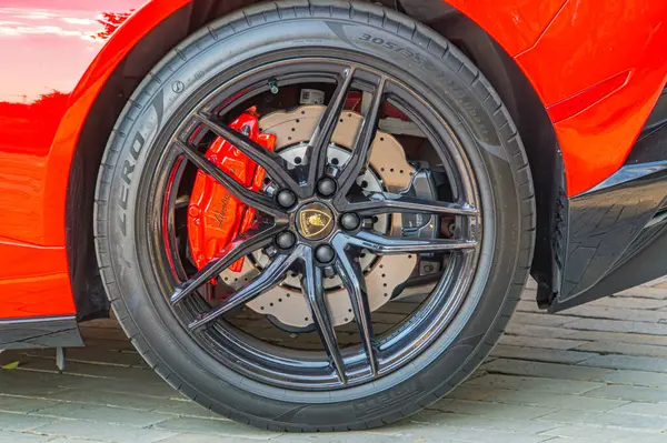 Görüntü lüks bir spor arabanın arka tekerleğini gösteriyor, parlak alaşımlı jantının beş telli ışığını yansıtıyor fren kalibreleri görünür ve renkli Kyiv, Ukrayna, 09-15-2024