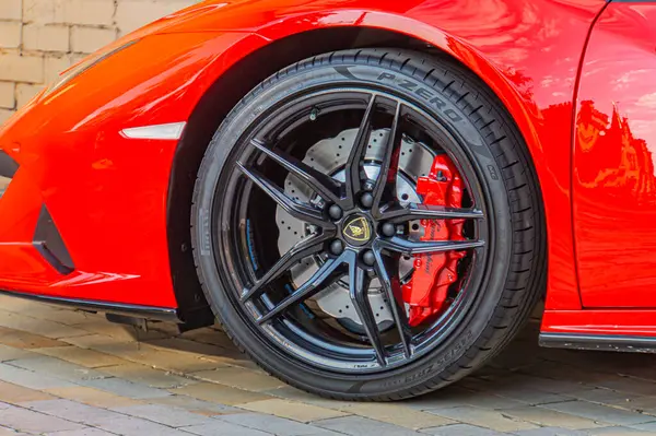 Siyah zıt jantlı kırmızı bir spor arabanın resmi, muhtemelen lüks ve sofistike Kyiv, Ukrayna, 09-15-2024 'ü temsil ediyor.