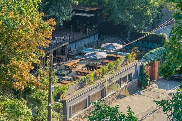Konforlu oturma yerleri, şemsiyeleri, yeşillikleri ve modern ve sıcak tasarım karışımı bir açık hava yemek alanı restoran sunumları veya etkinlikleri için idealdir Kyiv, Ukrayna, 09-15-2024