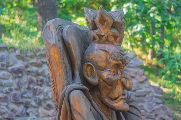 Ağaçların arasına ve bir taş duvara yerleştirilmiş bronz bir heykel, pazarlama kültürü, tarih, sanat etkinlikleri veya festivaller için kullanılabilir: Kyiv, Ukrayna, 09-15-2024