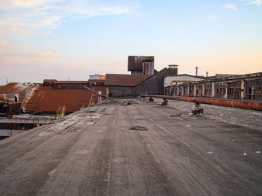 Gün batımında terk edilmiş bir endüstriyel tesis ya da gün doğumunda yıkılan binalar, dağınık enkazlar ve endüstriyel çürümeye odaklanmış sahne gerçekçi, değişen indu 'nun öyküsünü yakalıyor.