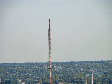 Yükselmiş bir iletişim kulesini ve temiz gökyüzünün altındaki düz araziyi gösteren bir görüntü.
