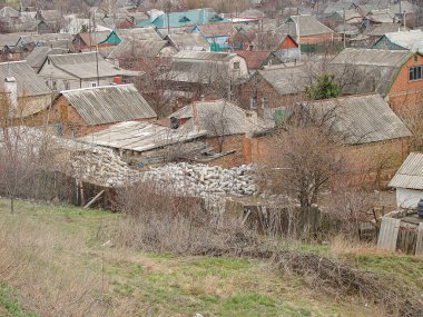 Muhtemelen bitki örtüsü için uygun olmayan iklimli evleri olan bakımsız bir yerleşim alanının görüntüsü yaşlanma ve ihmal belirtileri gösteriyor.
