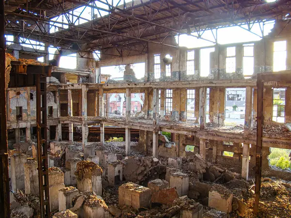 Görüntü yıkık dökük ve kırık camlı bir bina gösteriyor.