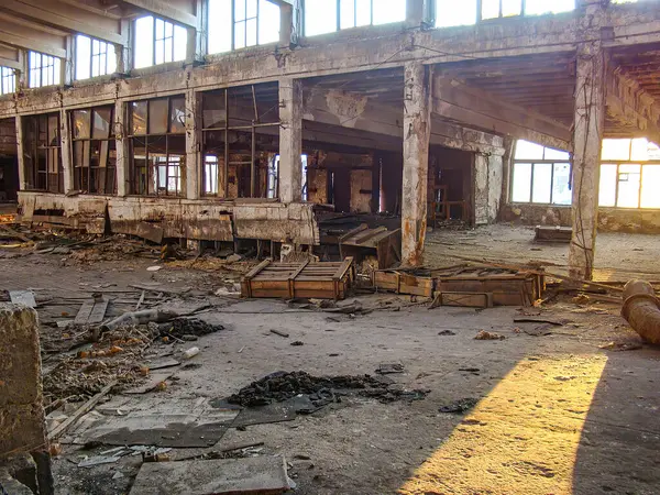 Hasarlı duvarları, tavanı ve paslı yapıları olan harap bir bina. Muhtemelen geçmişteki yangınlardan kalma.