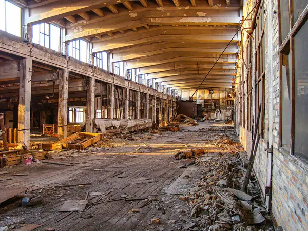 Görüntü, yıkılmış duvarları, enkazı ve geniş pencereleri olan terk edilmiş, harap olmuş bir endüstri binasını gösteriyor. Portre yöneliminde insan varlığı görünmüyor, fotoğraf Hig 'i vurguluyor.