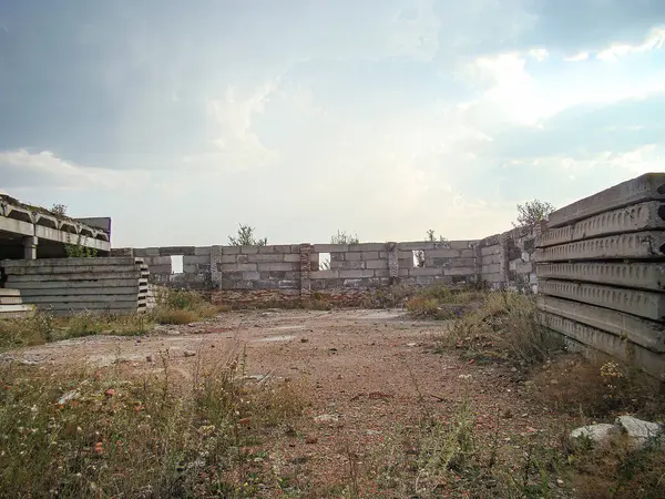 Çökmüş sanayi binası ya da kırık camlı kompleksi, kayıp duvarları ve aşırı gelişmiş bitki örtüsü beton kirişleri ve zemindeki beton levhalar serin ya da bulutlu bir günü işaret ediyor Surroun